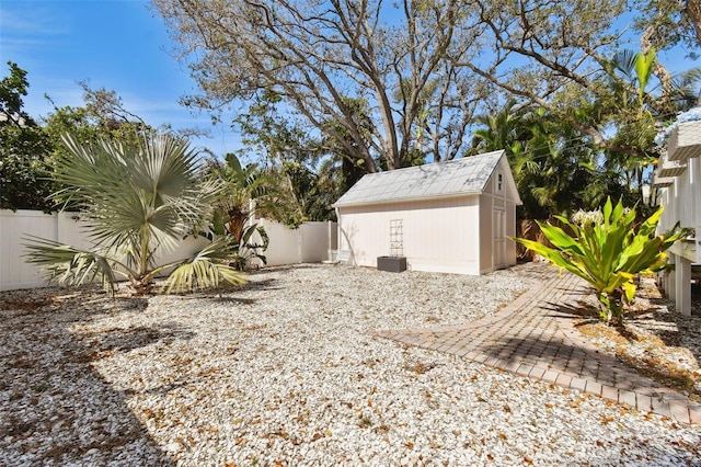 view of yard featuring a fenced backyard, an outbuilding, and a storage shed