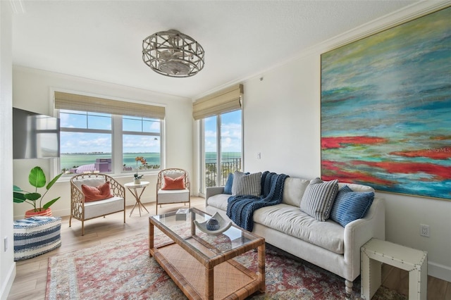 living room with wood finished floors, a water view, and ornamental molding