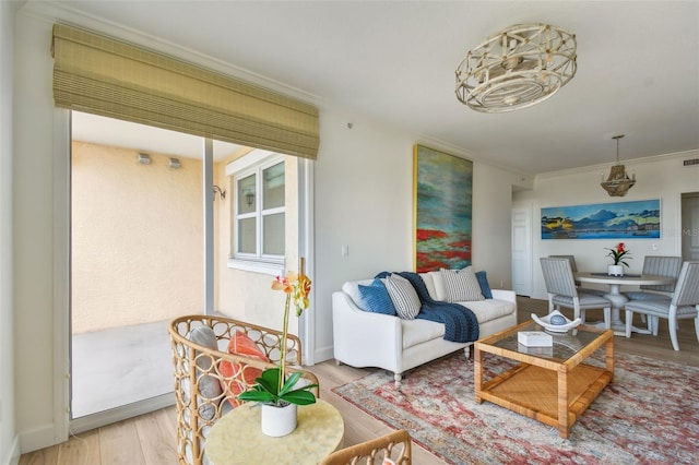 living room featuring visible vents, baseboards, wood finished floors, and ornamental molding