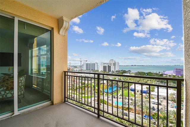 balcony with a water view and a view of city