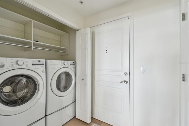 laundry room featuring washer and dryer, light wood-style floors, and laundry area