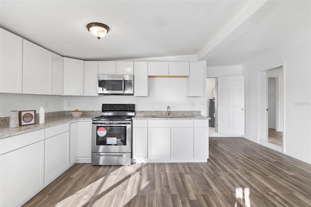 221 Duxbury Ave, Port Charlotte, FL 33952 - kitchen featuring appliances with stainless steel finishes, light stone countertops, wood finished floors, a sink, and white cabinetry