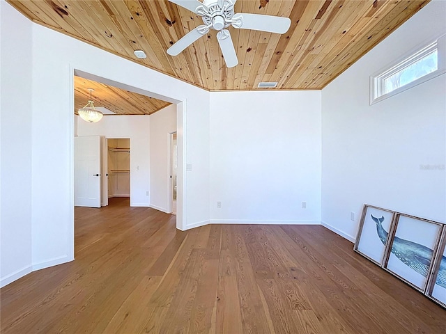 spare room featuring a ceiling fan, visible vents, wooden ceiling, wood finished floors, and baseboards