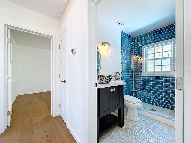 full bath featuring visible vents, toilet, vanity, wood finished floors, and a stall shower