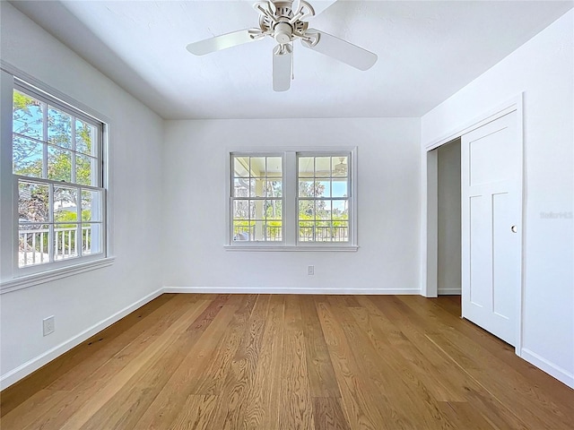unfurnished bedroom with wood finished floors, baseboards, and a ceiling fan