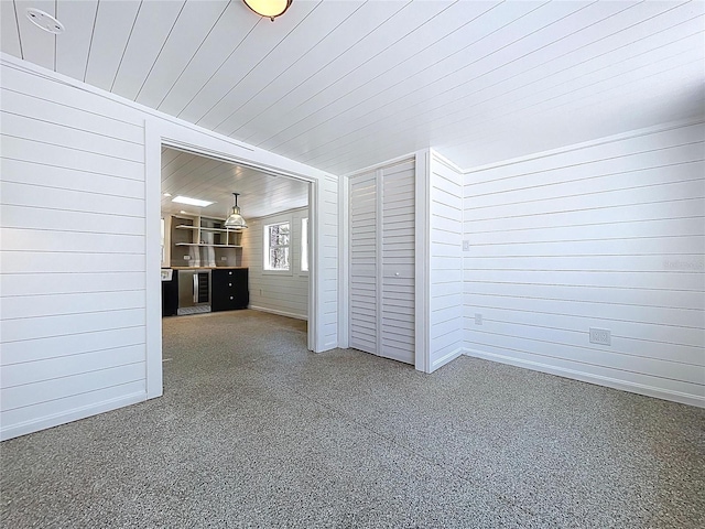 spare room with wood ceiling and wooden walls