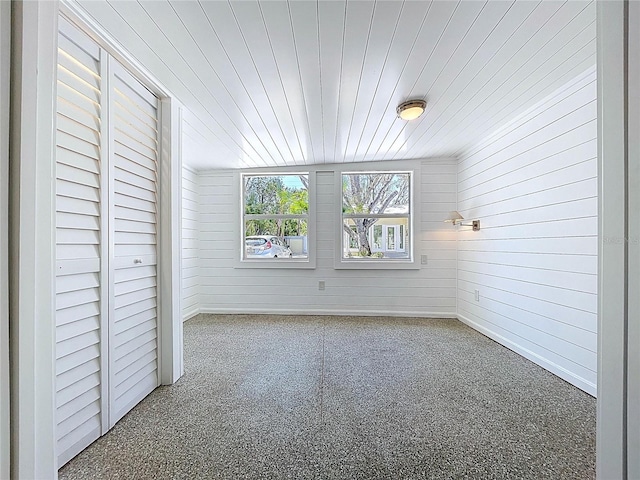 unfurnished bedroom with wooden walls and wood ceiling