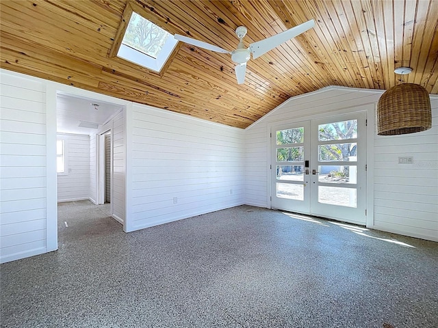 unfurnished living room with french doors, wood ceiling, lofted ceiling with skylight, and wood walls