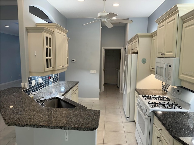 3312 92nd Ave E, Parrish, FL 34219 - kitchen with white appliances, cream cabinets, ceiling fan, backsplash, and a peninsula