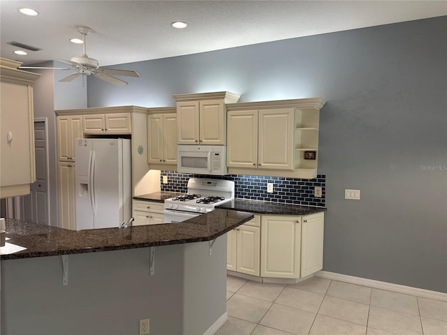 3312 92nd Ave E, Parrish, FL 34219 - kitchen with white appliances, a ceiling fan, backsplash, a kitchen bar, and recessed lighting