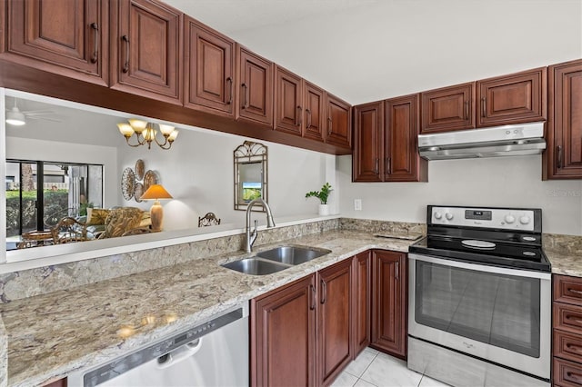 kitchen with light tile patterned floors, a sink, appliances with stainless steel finishes, under cabinet range hood, and light stone countertops
