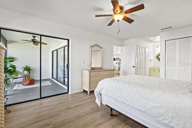 bedroom with ceiling fan, visible vents, access to exterior, wood finished floors, and baseboards
