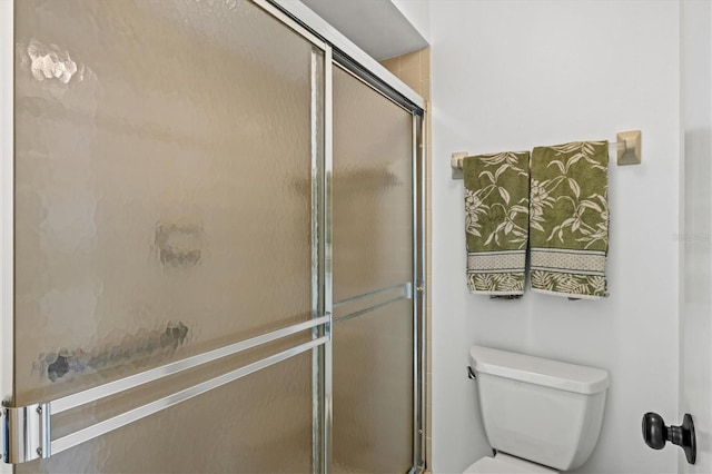 bathroom featuring toilet and a stall shower