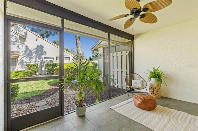unfurnished sunroom featuring ceiling fan