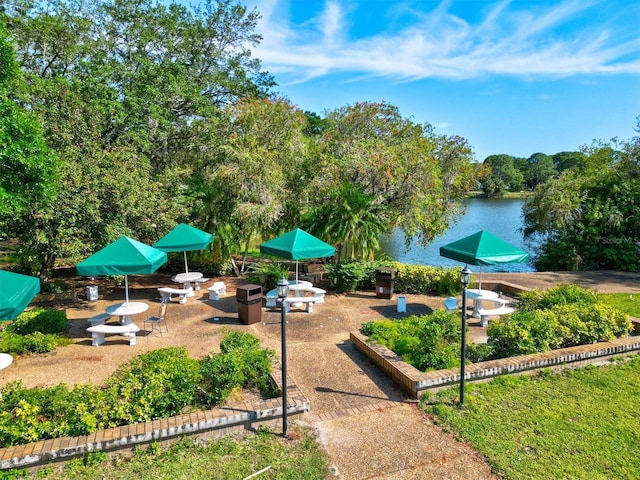 surrounding community featuring a patio, a fire pit, and a water view