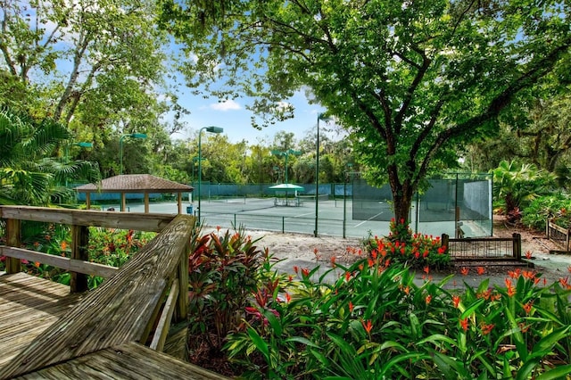 view of tennis court with a gazebo and fence