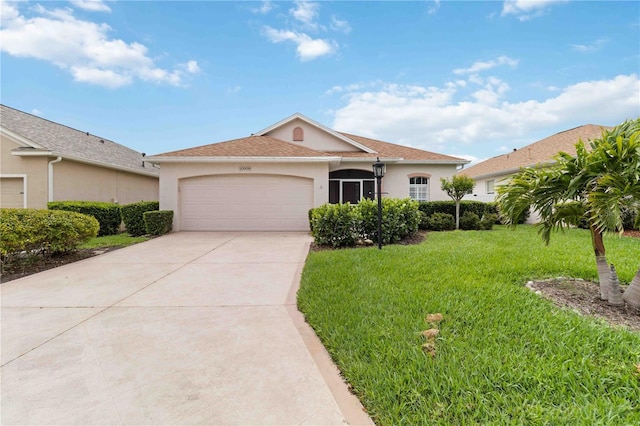 single story home with an attached garage, driveway, a front yard, and stucco siding