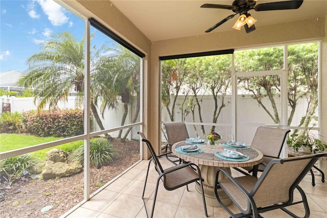 sunroom featuring a ceiling fan and outdoor dining space
