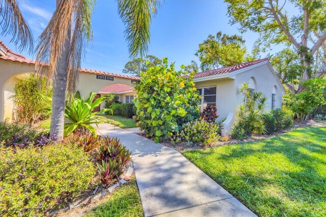 2267 Pueblo Ln Unit V40, Sarasota, FL 34231 - mediterranean / spanish house with stucco siding, a tiled roof, and a front yard