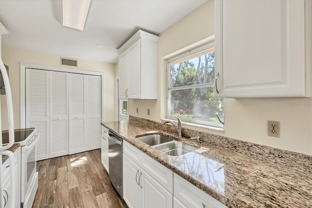 2267 Pueblo Ln Unit V40, Sarasota, FL 34231 - kitchen featuring a sink, white range with electric cooktop, stainless steel dishwasher, white cabinets, and light wood-type flooring