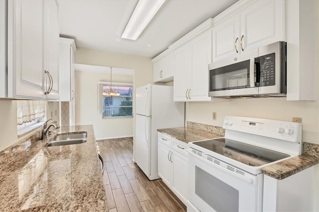 2267 Pueblo Ln Unit V40, Sarasota, FL 34231 - kitchen with white appliances, a sink, white cabinetry, and wood finished floors