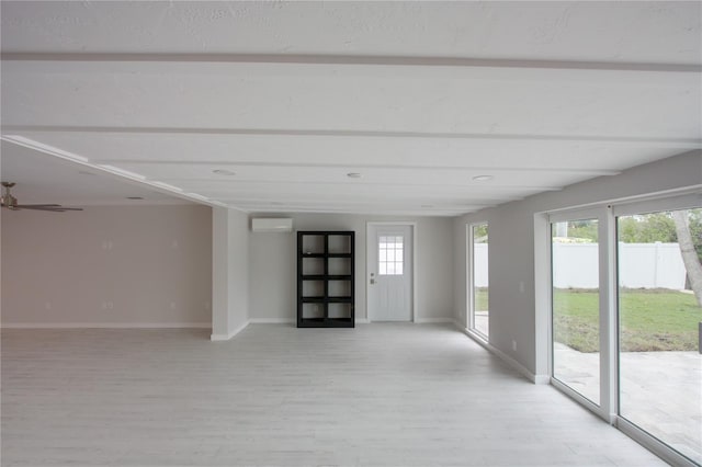 306 Island Cir, Sarasota, FL 34242 - empty room with a wall mounted AC, light wood-style flooring, and baseboards