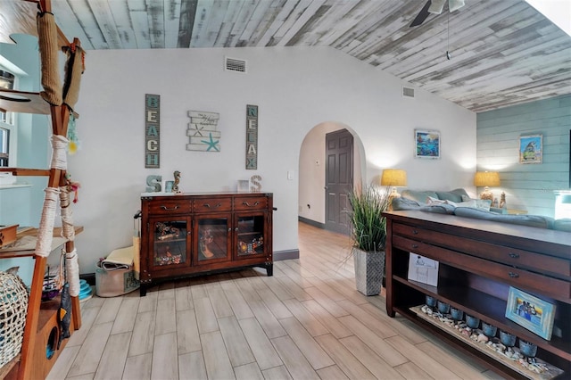 23088 Allen Ave, Port Charlotte, FL 33980 - living area with arched walkways, lofted ceiling, a ceiling fan, wood finished floors, and wooden walls