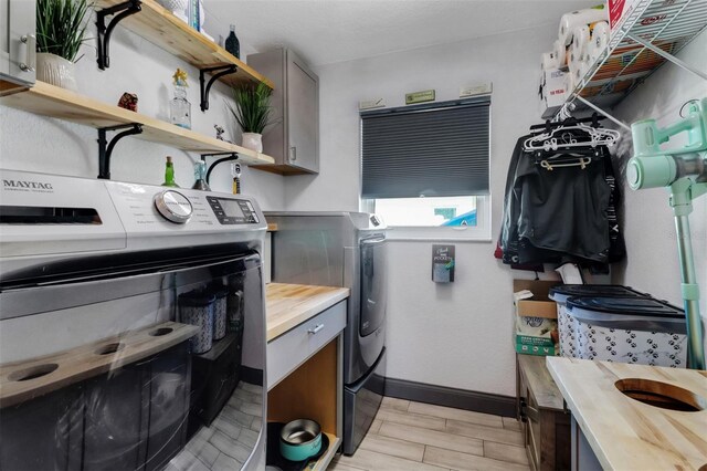 23088 Allen Ave, Port Charlotte, FL 33980 - washroom with washer and dryer, cabinet space, and wood finish floors