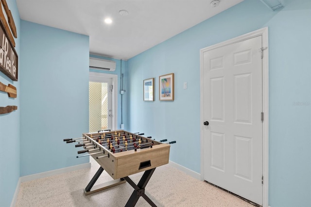 recreation room featuring recessed lighting, a wall mounted AC, baseboards, and speckled floor