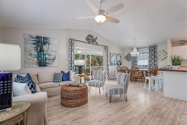 living area with light wood-style flooring, ceiling fan with notable chandelier, and lofted ceiling