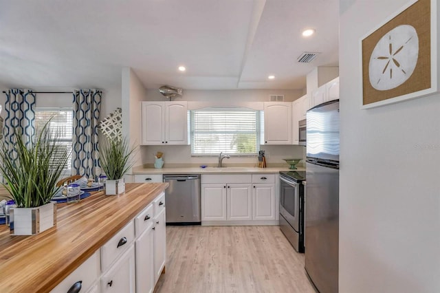 kitchen featuring a healthy amount of sunlight, a sink, visible vents, and stainless steel appliances
