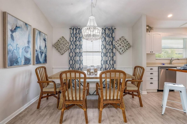 dining space with a chandelier, light wood-type flooring, and baseboards