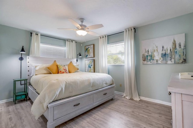 bedroom with light wood-style floors, ceiling fan, and baseboards