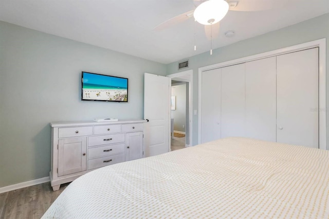 bedroom with a closet, baseboards, visible vents, light wood-type flooring, and a ceiling fan