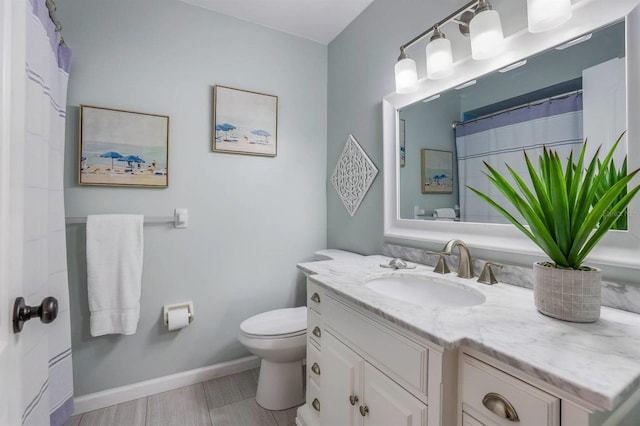 full bath with vanity, baseboards, toilet, and wood finished floors