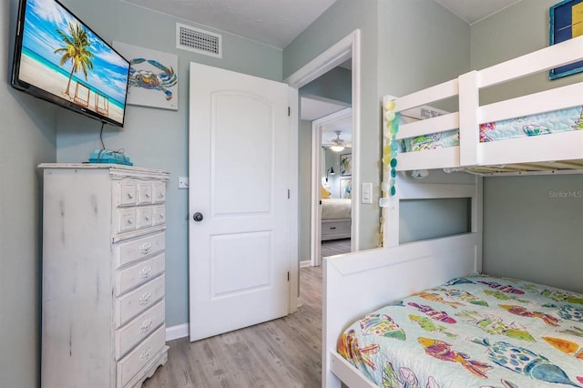 bedroom with visible vents, baseboards, and wood finished floors