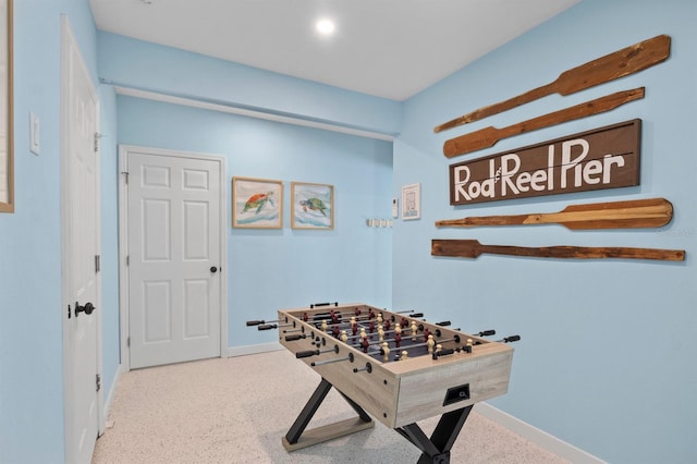 rec room featuring speckled floor and baseboards