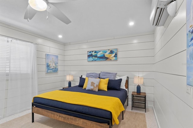 bedroom with light speckled floor, a ceiling fan, wooden walls, recessed lighting, and a wall unit AC