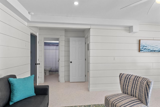 living area featuring speckled floor and a ceiling fan