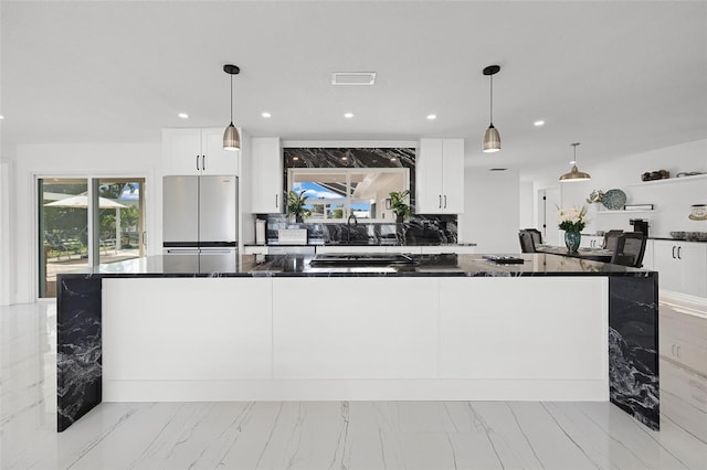 kitchen with marble finish floor, white cabinetry, and stainless steel fridge