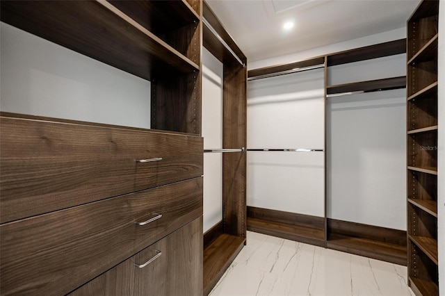 walk in closet featuring marble finish floor