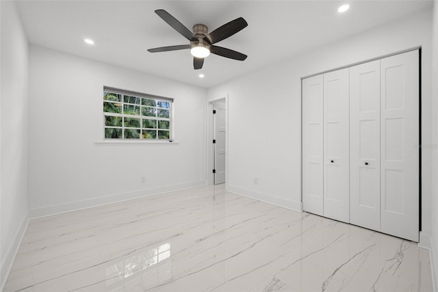 unfurnished bedroom featuring a closet, marble finish floor, baseboards, and recessed lighting