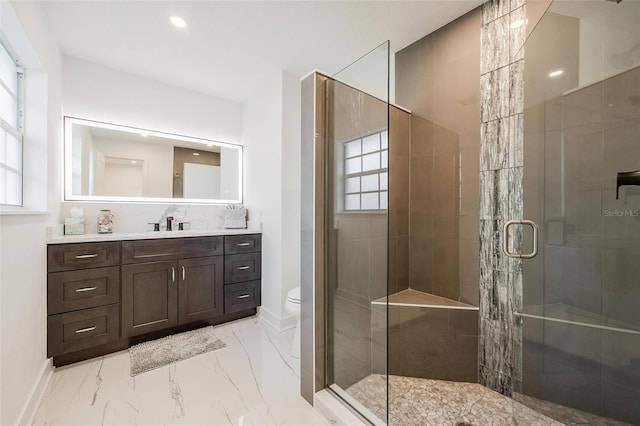 bathroom with a shower stall, vanity, toilet, marble finish floor, and baseboards