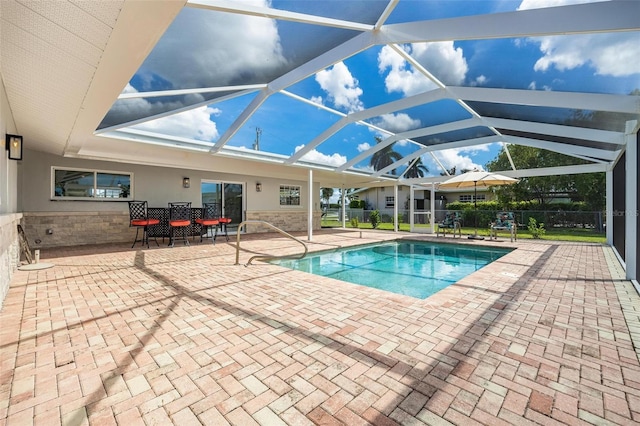 view of swimming pool featuring a patio area, glass enclosure, and a fenced in pool