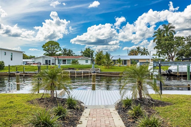 view of dock featuring a water view, a lawn, and boat lift