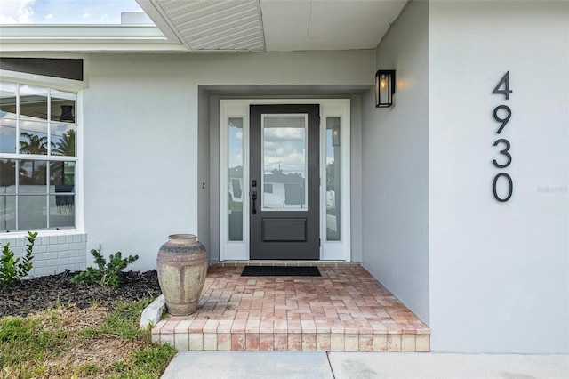 property entrance with stucco siding