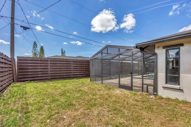 view of yard with an outdoor pool, a fenced backyard, and glass enclosure