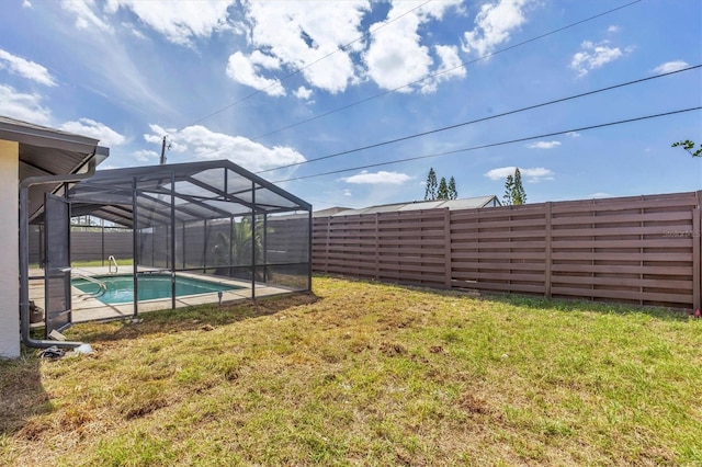 view of yard with a fenced backyard, a fenced in pool, and glass enclosure