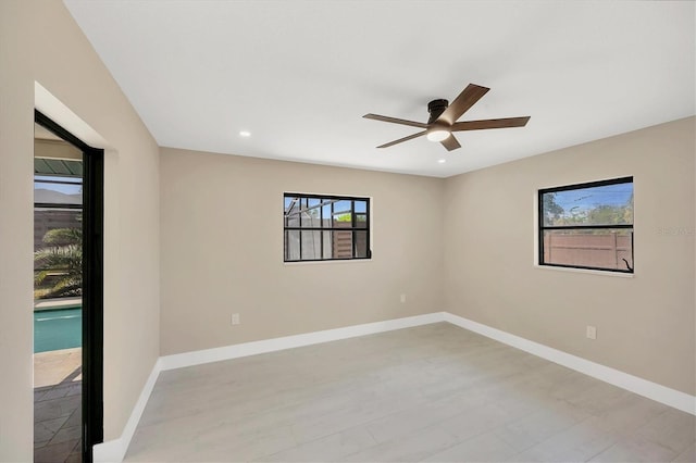 unfurnished room with a ceiling fan, baseboards, and a healthy amount of sunlight