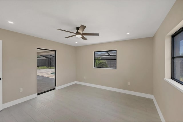 unfurnished room featuring ceiling fan, baseboards, wood finished floors, and plenty of natural light